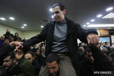 A member of the Palestinian Islamist Hamas movement is greeted by supporters before at the movement's leader Ismail Haniyeh's office in the Gaza Strip on February 28, 2019. - The Hamas leader announced in a press release...