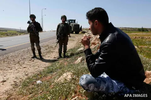 Israeli soldiers stand guard as an Israeli army bulldozer demolish a land in al-Simiya village near the West Bank city of Hebron, on March 11, 2019. Israeli forces razed and leveled the debris of a Palestinian elementary...
