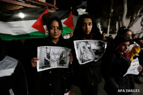 Palestinians hold banners as they participate in a protest against Friday's mass shootings in New Zealand, in the West Bank city of Bethlehem on March 17, 2019. The live-streamed attack by an immigrant-hating white natio...
