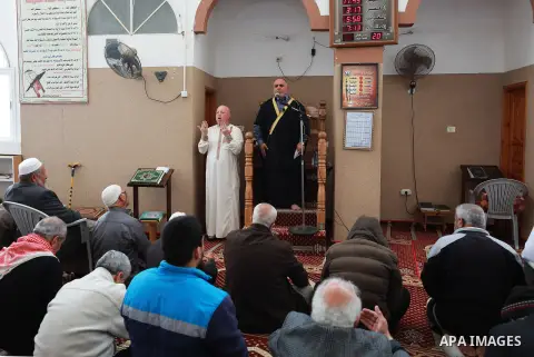 Mohammed Abu Ghola (L), a Palestinian sign language trainer, translates into sign language to deaf muslim worshipers during Friday prayers, at a mosque in al-Zawaydah destrict, in the central Gaza Strip, March 22, 2019....