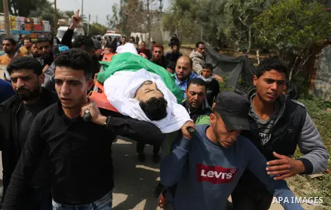 Mourners carry the body of Palestinian Nidal Shatat, 29, who was shot dead by Israeli forces during clashes with Israeli troops in tents protest where Palestinians demand the right to return to their homeland at the Isra...