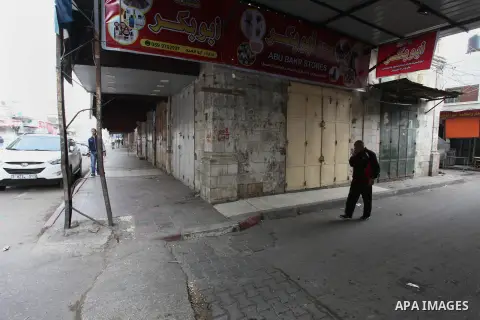 Palestinians walk past closed shops during a general strike marking the Land Day in Gaza city on March 30, 2019. This year, Land Day coincides with the first anniversary of the Great March of Return protests in the Gaza...