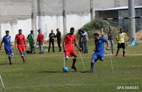 Palestinian amputees using crutches play a football match during the first football tournament for amputees, at Palestine Stadium in Gaza city, on April 13, 2019. More than 125 have had amputations shot by Israeli forces...