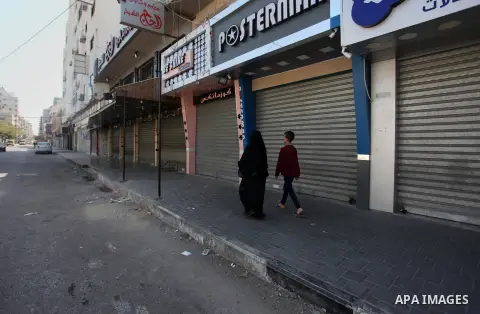 Palestinians walk past closed shops during a general strike marking the 71st anniversary of the "Nakba in Gaza city on May 15, 2019. The "Nakba," or catastrophe, commemorates the mass displacement of more than 700,000 Pa...