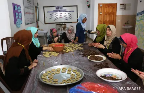 Palestinian youths prepare traditional cookies ahead of the Eid al-Fitr festivities, celebrating the end of the holy Muslim fasting month of Ramadan, at al-Maghazi camp in the center of Gaza Strip on May 29, 2019. Photo...