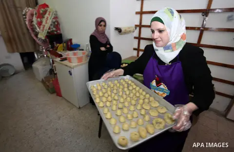 A Palestinian woman prepares traditional cookies ahead of the Eid al-Fitr festivities, celebrating the end of the holy Muslim fasting month of Ramadan, in Gaza city on May 30, 2019. Photo by Mahmoud Ajjour