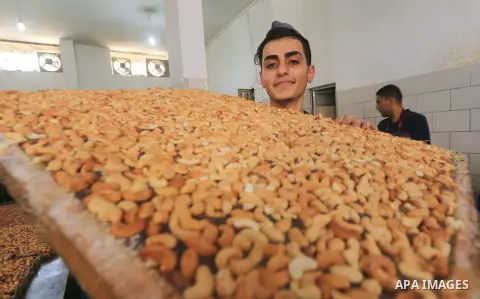 Palestinians prepare sweet known in Arabic as "Halkoum" in a store to be sold ahead of the Eid al-Fitr holiday in Gaza city on May 30, 2019. Eid al-Fitr marks the end of Muslim's holy fasting month of Ramadan when faithf...