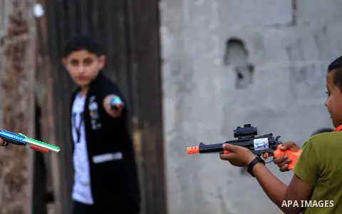 Palestinian boys play with toy guns to celebrate on the second day of Eid al-Fitr holiday which marks the end of the Muslim holy month of Ramadan in Dair Al Balah in the center of Gaza strip, on June 6, 2019. Photo by Ma...