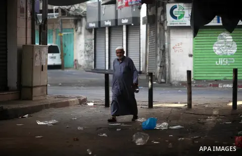 Palestinians walk past closed shops during a general strike against the economic workshop in Bahrain in Gaza city on June 25, 2019. The Palestinian Ministry of Foreign Affairs said “Trump administration is re-producing t...