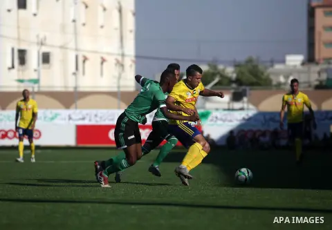 Palestinian players of Khadamat Rafah club (green T-shirt), and players of Shabab Balata club (yellow T-shirt), play during the Palestine cup championship, in Rafah in the southern Gaza Strip on June 30. 2019. The game e...