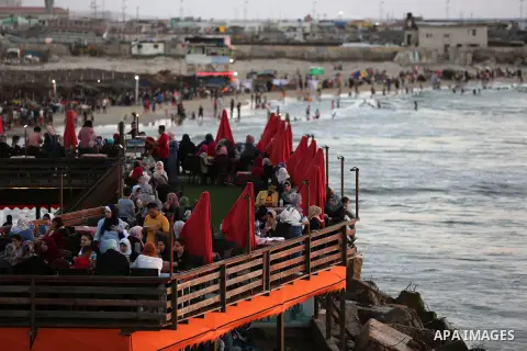 Palestinians site in a cafe on the beach ialong the shore of the Mediterranean Sea as they escape from the summer heat, in Gaza City July 01, 2019. Photo by Ashraf Amra