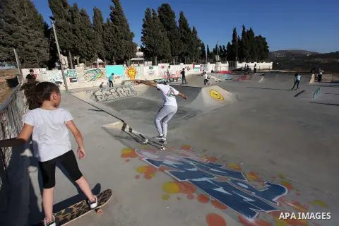 Palestinians and foreign activists skateboard in a skatepark in the village of Asira ash-Shamaliya, near the West Bank city of Nablus, July 02, 2019. Skateboarding is an action sport which involves riding and performing...