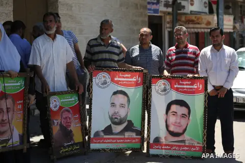 Palestinians hold placards during a protest in solidarity with prisoners on hunger strike against administrative detention, in Gaza city on July 03, 2019. Photo by Ashraf Amra