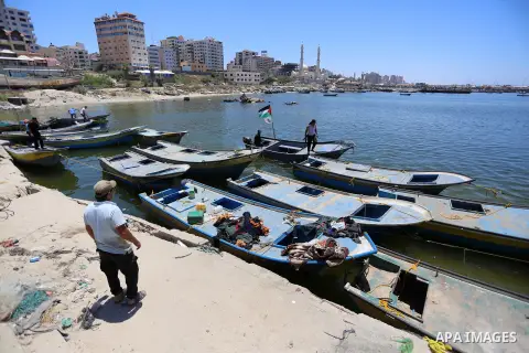 Palestinians look at fishing boats at the Gaza sea port after it was delivered by Israeli forces, in the east of Gaza city, July 03, 2019. Israel and Hamas reportedly renewed a truce agreement last week and agreed to sen...
