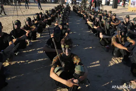 Young Palestinians, carrying a wooden rifle, chants slogans during a military-style graduation ceremony organised by the Islamic Jihad movement in Gaza City on July 4, 2019. Photo by Ashraf Amra