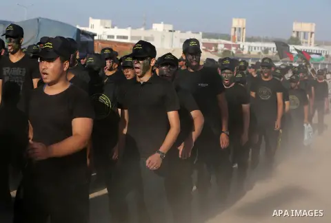 Young Palestinians, carrying a wooden rifle, chants slogans during a military-style graduation ceremony organised by the Islamic Jihad movement in Gaza City on July 4, 2019. Photo by Ashraf Amra