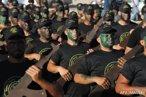 Young Palestinians, carrying a wooden rifle, chants slogans during a military-style graduation ceremony organised by the Islamic Jihad movement in Gaza City on July 4, 2019. Photo by Ashraf Amra