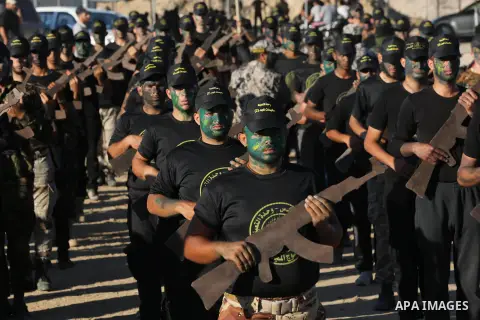 Young Palestinians, carrying a wooden rifle, chants slogans during a military-style graduation ceremony organised by the Islamic Jihad movement in Gaza City on July 4, 2019. Photo by Ashraf Amra