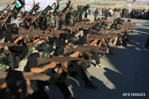 Young Palestinians, carrying a wooden rifle, chants slogans during a military-style graduation ceremony organised by the Islamic Jihad movement in Gaza City on July 4, 2019. Photo by Ashraf Amra