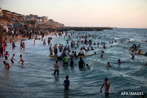 Palestinians enjoy at the beach along the shore of the Mediterranean Sea during the sunset, in Gaza City July 05, 2019. Photo by Mahmoud Ajjour