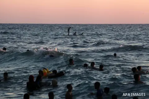 Palestinians enjoy at the beach along the shore of the Mediterranean Sea during the sunset, in Gaza City July 05, 2019. Photo by Mahmoud Ajjour