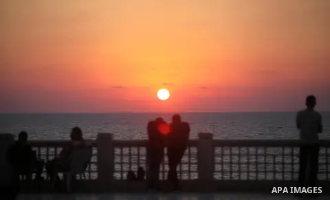 Palestinians enjoy at the beach along the shore of the Mediterranean Sea during the sunset, in Gaza City July 05, 2019. Photo by Mahmoud Ajjour