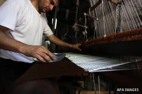 Palestinian workers weave carpets in a workshop in Gaza city on July 06, 2019. Weaving sheep's wool into traditional carpets is one oldest professions, it takes skill, patience and steady hand. Photo by Mahmoud Ajjour