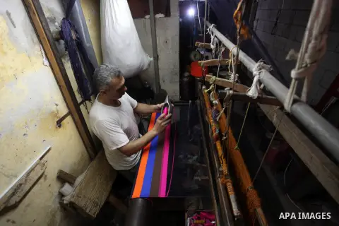 Palestinian workers weave carpets in a workshop in Gaza city on July 06, 2019. Weaving sheep's wool into traditional carpets is one oldest professions, it takes skill, patience and steady hand. Photo by Mahmoud Ajjour
