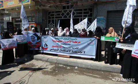 Palestinians hold placards during a protest against the political arrests in the West Bank, in Gaza city, on July 15, 2019. Photo by Mahmoud Ajjour