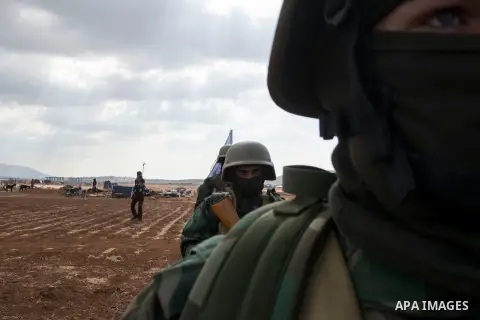 Fighters of Jaysh al-Izza formation of the Syrian armed opposition, take part in a military show during their graduation from a special forces course in Idlib, where medium and heavy weapons were used to prepare them to...
