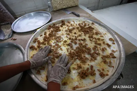 A Palestinian worker prepares sweets ahead of the results of high school exams, known as ''Tawjihi'', at a workshop in Gaza city, July 17, 2019. Photo by Mahmoud Ajjour