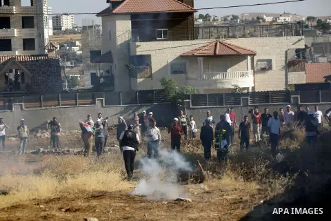 Palestinians run for cover from tear gas canisters fired by Israeli forces during clashes following a demonstration against the demolishing of buildings in the Palestinian village of Beit Sahur in the West Bank city of B...