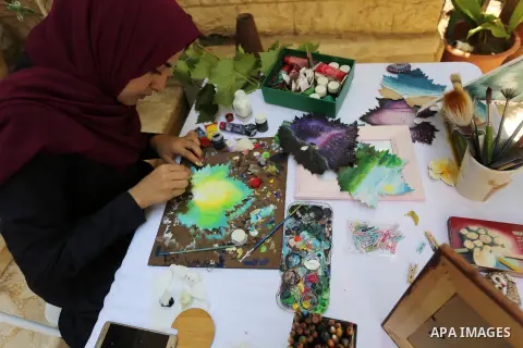Palestinian artist Leen al-Hajj, 21, paints on a grape leaf at her house in Nusierat refugee camp, in the central Gaza Strip, July 23, 2019. Al-Hajj was able to convert grape leaves, which is the popular dish in the cuis...