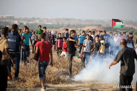 Palestinian protesters clash with Israeli troops following the tents protest where Palestinians demand the right to return to their homeland at the Israel-Gaza border, in the central of Gaza Strip, July 26, 2019. Photo b...