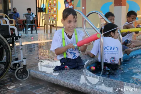 Amputee Palestinian children play in a swimming pool during a summer camp organised by Palestinian children's relief fund (PCRF), in Khan Younis in the southern Gaza Strip, July 30, 2019. Photo by Mariam Dagga