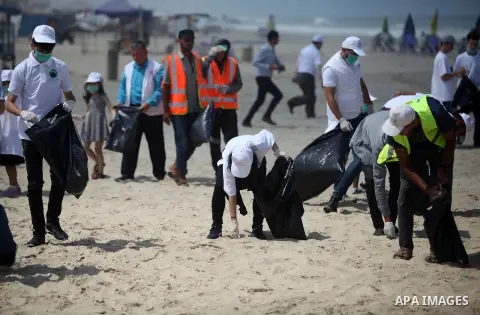 Palestinian youths take part in the cleaning of the beach along the shore of the Mediterranean Sea under the title "Our beach is clean with our behavior" organaized by JICA Alumni Association in Palestine, in Gaza city o...