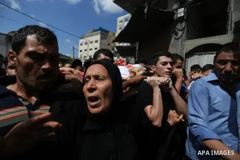 Mourners carry the body of Palestinian Sami al-Ashqar, 17, who was shot dead by Israeli forces at the Israel-Gaza border, during his funeral in Jabalia in the northern Gaza Strip. Photo by Ashraf Amra