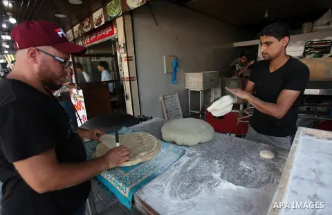 A Palestinian man bakes traditional bread "Taboon", in Gaza city, on September 22, 2019. Photo by Mahmoud Ajjour