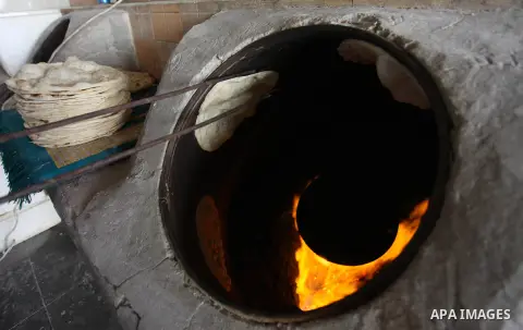 A Palestinian man bakes traditional bread "Taboon", in Gaza city, on September 22, 2019. Photo by Mahmoud Ajjour