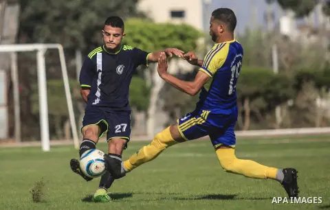 Palestinian football players of Etihad Beit Hanoun (blue) and Alhilal (Dark blue) compete during match premier League in Alyarmuk stadium, in Gaza City on September 22, 2019. Photo by Mahmoud Ajjour