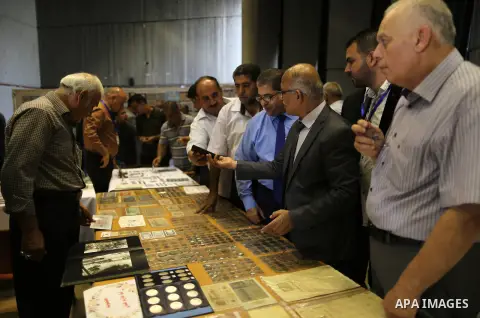 Palestinians attend the second exhibition of coins and postage stamps, in Gaza City on October 6, 2019. Photo by Ashraf Amra