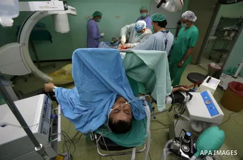 Egyptian doctors take part in surgery for a Palestinian, who was injured during the clashes with Israeli troops at the European Gaza Hospital in Khan Yunis in the southern Gaza Strip, on October 12, 2019. Photo by Ashraf...