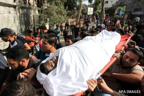 Mourners carry the body of Palestinian Emad Shaheen, 18, during his funeral after his body was released by Israel, in Nuseirat in the central Gaza Strip on October 23, 2019. Photo by Mahmoud Ajjour