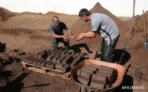 A Palestinian worker makes briquettes from olive pulp (also called olive pomace or olive cake) that is obtained from the olive oil extraction process and used as an energy source, at an olive press factory in Khan Younis...