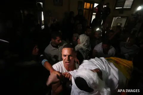 Relatives of Palestinian Ahmed Al-Shahri, 27, who was killed in an Israeli strike, mourn over his body during his funeral in Khan Younis in the southern of Gaza Strip, on November 2, 2019. Photo by Ashraf Amra