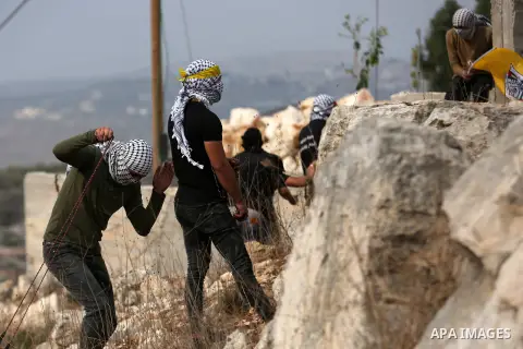 Palestinian protesters hurl stones towards Israeli security forces during clashes following a weekly demonstration against the expropriation of Palestinian land by Israel in the village of Kfar Qaddum, near the West Bank...