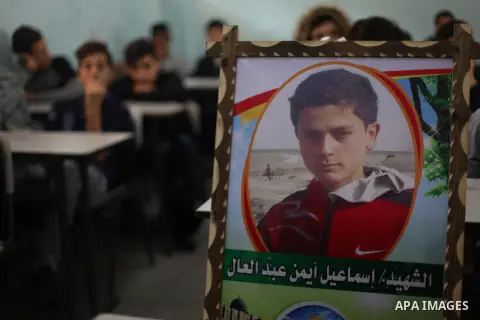 A picture of Palestinian student boy Ismail Abd El-Aal,16, who was killed in an Israeli air strike on the Gaza Strip, is seen on his study seat next to his classmates at a school, in Gaza City, on November 16, 2019. Phot...