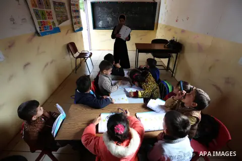 Palestinian schoolchildren attend a lesson after Israeli troops confiscated caravans used as school classrooms, due to the lack of an Israeli-issued construction permit, at Ghassan Kanafani Kindergarten in the West Bank...