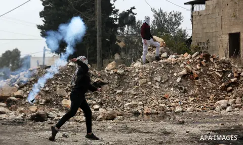 A Palestinian protester returns throwing a tear gas canister during clashes following a weekly demonstration against the expropriation of Palestinian land by Israel in the village of Kfar Qaddum, near the West Bank city...