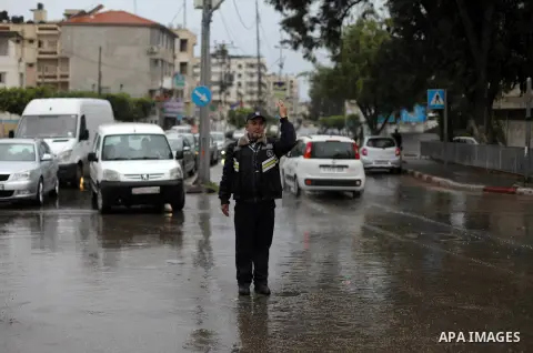 Palestinians walk in a street during a rainy day in Gaza city on December 15, 2019. Photo by Mahmoud Ajjour